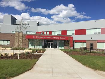 The front of St Therese of Lisieux Catholic School with a walkway leading to the entrance.